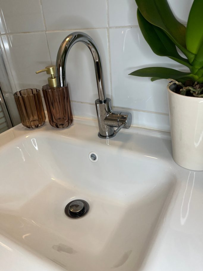 Mise en scène de la vasque Vasque blanche mise en scène avec orchidée et accessoires en verre fumé
