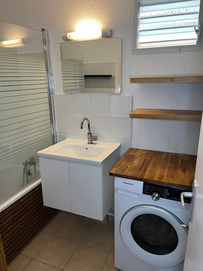 Salle de bain après travaux Salle de bain après rénovation avec meuble vasque, étagères en bois et plan de travail