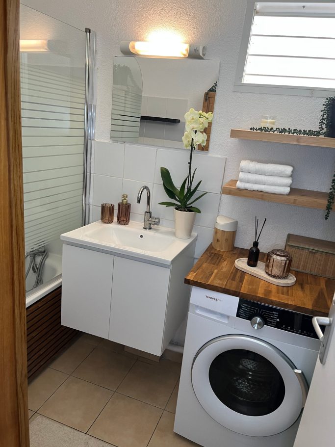 Salle de bain après home staging Salle de bain finale après home staging avec orchidée, bois et accessoires décoratifs